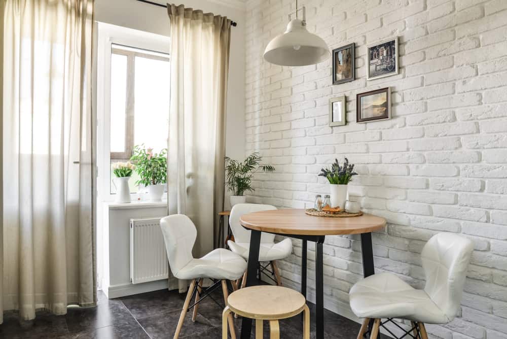 Bouquet of tulips in interior of the kitchen in Scandinavian style with white furniture and a dining table. All photos in photo frames on whall made by me.