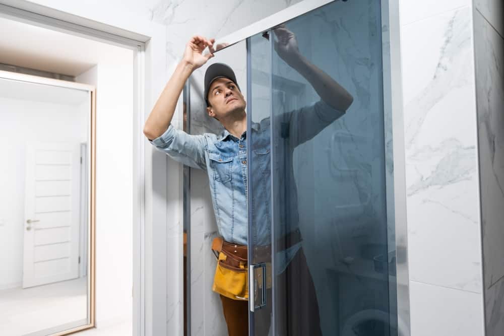 contractor installing glass shower door